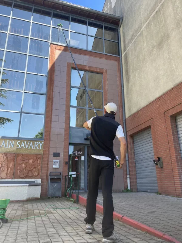 Technicien Toposmose nettoyant une façade à l’aide d’un nettoyeur haute pression